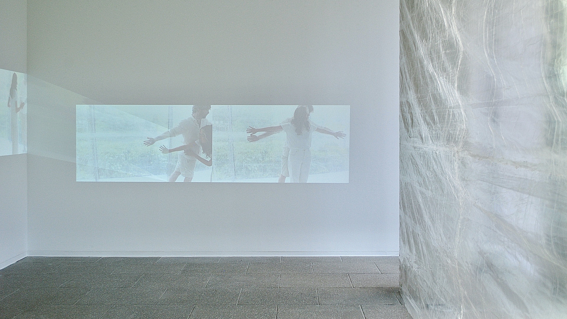 Cos Ahmet, A Meniscus Between, 2021 - Installation view. Two channel digital video projection, 5 mins 2 secs, audio, choreographic object, clear tape. Dimensions variable.